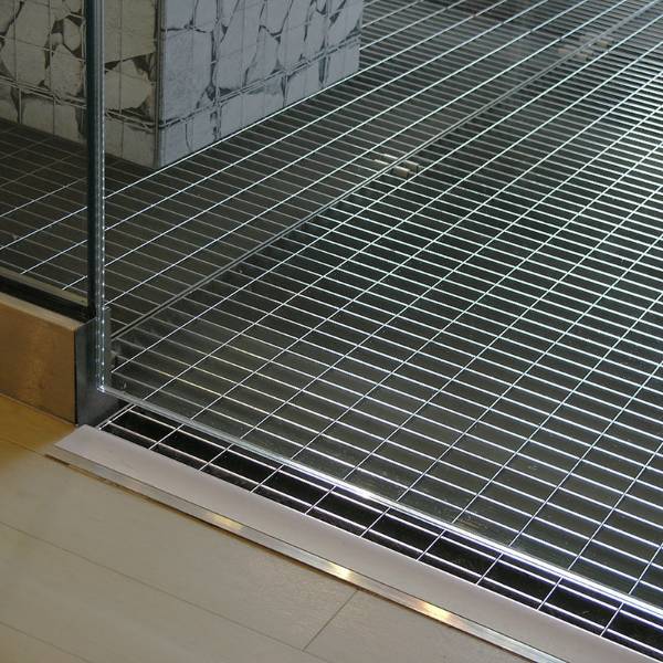 Primark - stainless steel floor grating serving as a light-well, introducing natural light to a basement shopping area