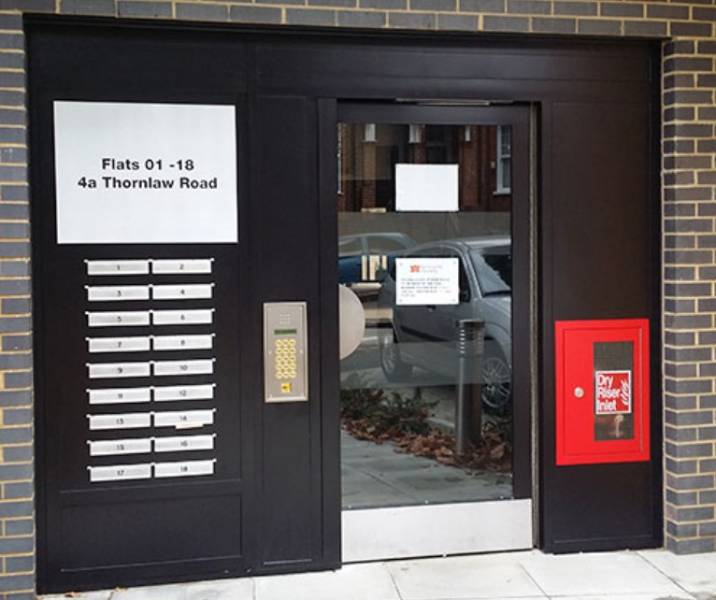 Integrated communal entrance door and post box