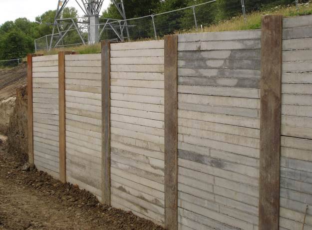 Driven king post retaining wall systems