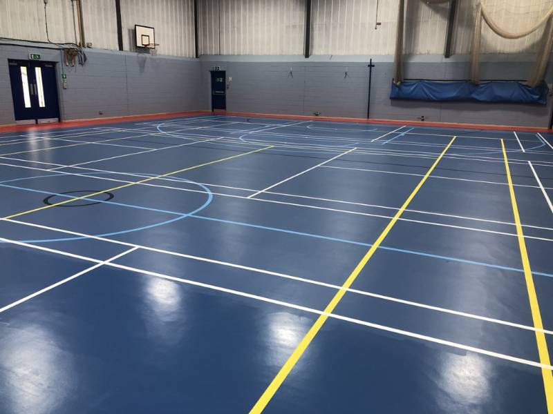 Recoating a resilient sports floor