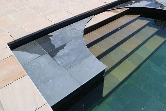 Raj Green Sandstone Paving and Pool Copings with a contrast Brazilian Black Slate Roman End